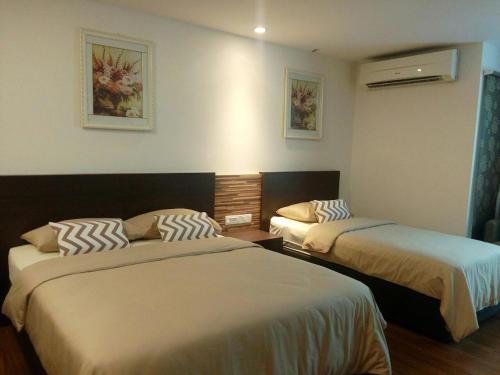 una habitación de hotel con 2 camas en una habitación en Dar Es Salam en Kota Bharu