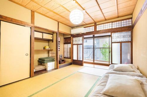 a large room with two beds and windows at Guest House Hitsujian in Kyoto