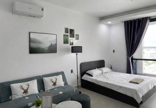 a bedroom with a bed and a couch at SOHA House in Rạch Giá