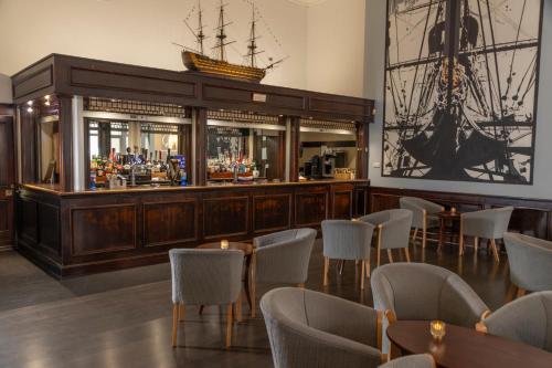 a bar with tables and chairs in a room at Royal Maritime Hotel in Portsmouth