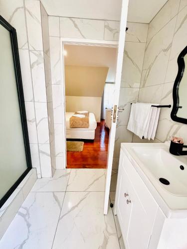a bathroom with a sink and a bed in a room at The Corner Guesthouse in Pietermaritzburg