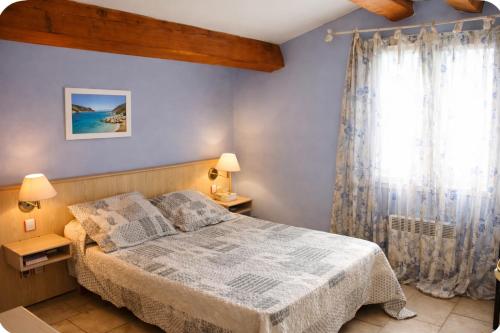 a bedroom with a bed and a window at Gîte Le Verdon in Quinson