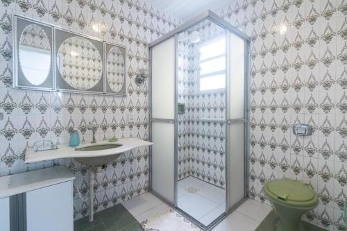 a bathroom with a shower and a toilet and a sink at Guest House Central in Florianópolis