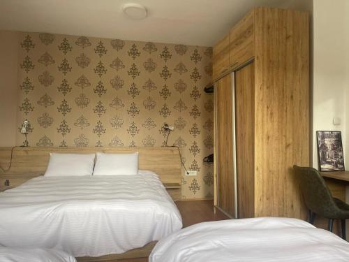 a bedroom with a white bed and a wall with wallpaper at Urban Boutique Apartments in Bitola