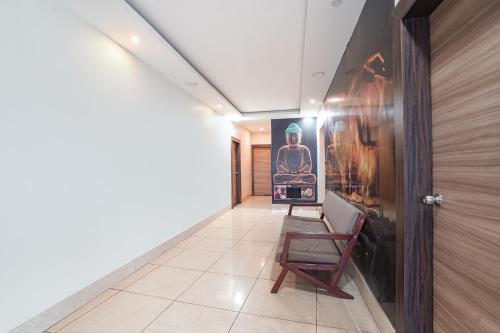 a hallway with a chair and a painting on the wall at FabHotel Garden Tree in Bhubaneshwar