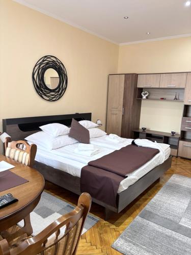 a bedroom with a large bed with a table and a mirror at Baross-hat 5 in Szolnok