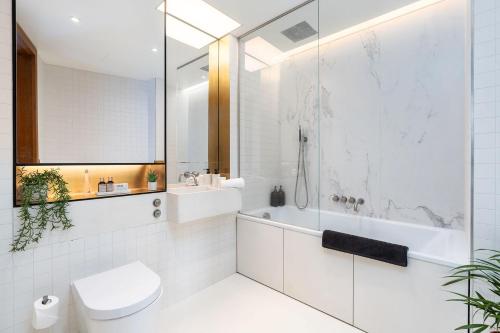 a bathroom with a shower and a toilet and a sink at Designer Stay at Kings Cross Gasholders with Balcony in London