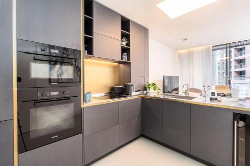 a kitchen with stainless steel appliances and a large window at Designer Stay at Kings Cross Gasholders with Balcony in London