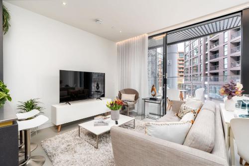 a living room with white furniture and a large window at Designer Stay at Kings Cross Gasholders with Balcony in London