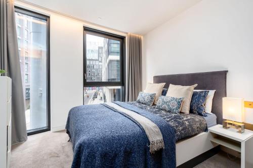 a bedroom with a bed and a large window at Designer Stay at Kings Cross Gasholders with Balcony in London