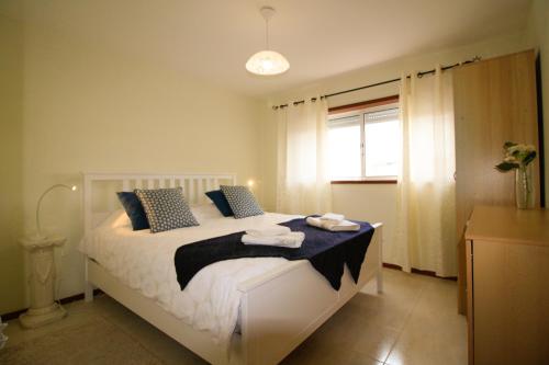 een slaapkamer met een bed met handdoeken erop bij Casa Lagoa Verde in Esmoriz
