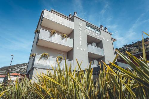 ein Gebäude mit Pflanzen davor in der Unterkunft Boutique Hotel Villa Alberta in Nago-Torbole