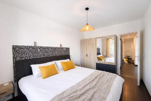 a bedroom with a large white bed with orange pillows at M031 Joli t3 centre d'Annemasse in Annemasse