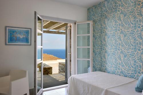 a room with a bed and a view of the ocean at Villa Litharia, enchanting location and view in Ioulis