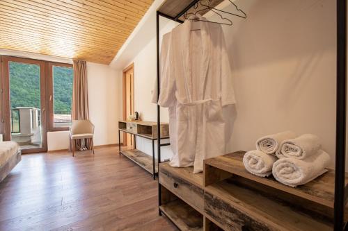 a bedroom with a robe and towels in a room at Anne's Hotel in Mestia in Mestia