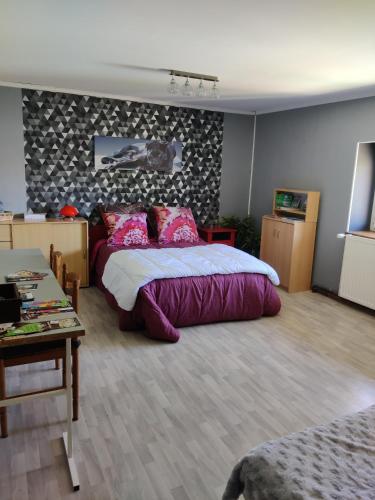 a bedroom with a large bed and a table at Au Jardin d'Isa in La Résie-Saint-Martin