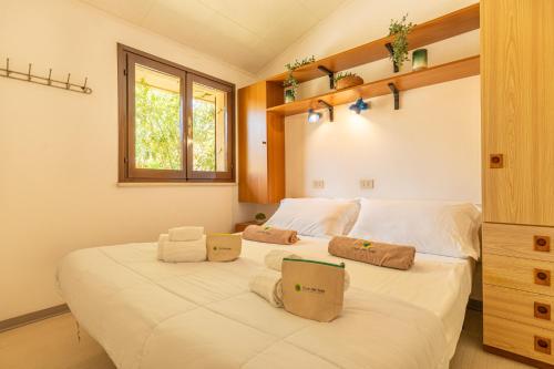 a bedroom with a large white bed with a window at Club del Sole La Risacca Family Collection in Porto SantʼElpidio