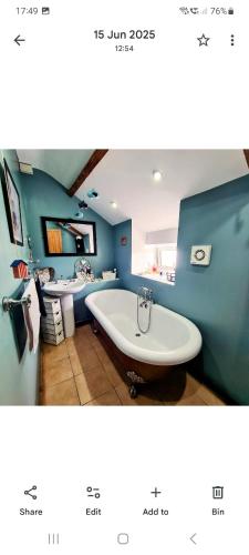 a bathroom with two sinks and a bath tub at Cute Quirky Cottage in Llandow