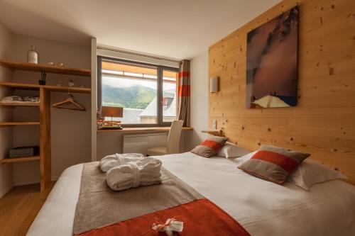 a bedroom with two beds and a large window at Maison Seignou in Azet