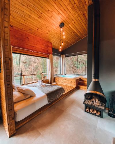 a bedroom with a bed and a large fireplace at Refúgio do Vale Estalagem in Annitapolis