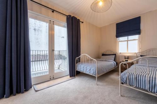 a bedroom with two beds and a balcony at Pump House Apartments in Derry Londonderry