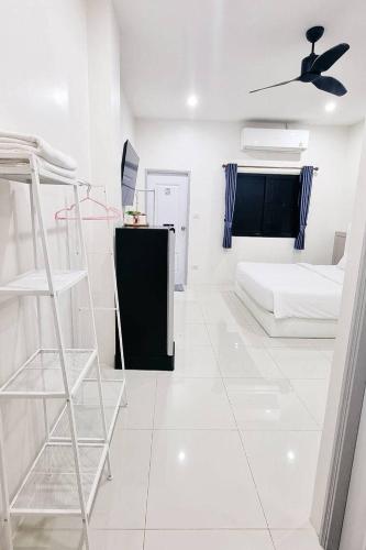 a white room with a bed and a ladder at Dad N Mom's House By Thongnak Apartment in Pattaya