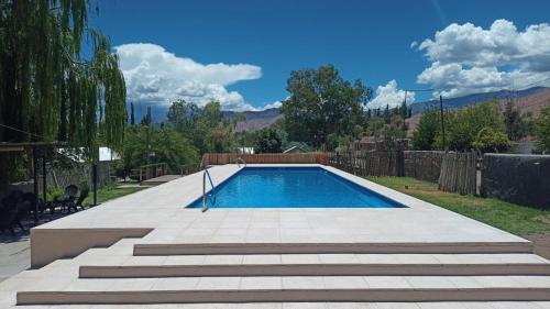 a swimming pool in a yard with a fence at Hotel de Campo Calingasta in Calingasta