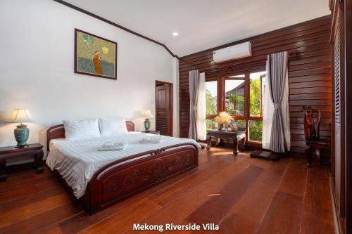 a bedroom with a large bed and a window at Mekong Riverside Villa in Vientiane