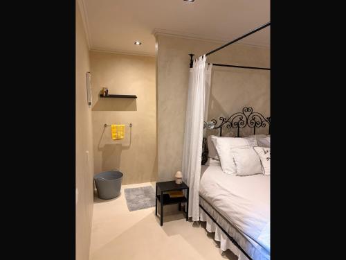 a bedroom with a bed with a metal canopy at Gastenverblijf de paddestoel in Urk