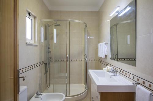 a bathroom with a shower and a sink and a toilet at Villa Maresia by Algarve Holidays in Galé