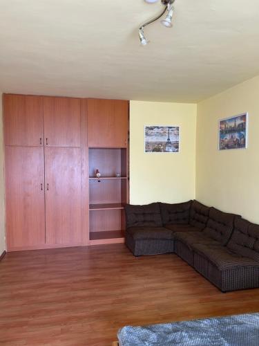 a living room with a couch and wooden cabinets at Szekcsői Kuckó in Kaposszekcső