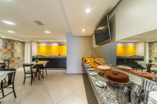 ein Restaurant mit einer Theke, auf der Essen angeboten wird in der Unterkunft Minuano Hotel Express próx Orla Lago Guaíba, Mercado Público, 300 m Rodoviária in Porto Alegre