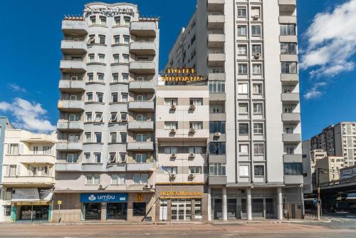 ein hohes weißes Gebäude in einer Stadt in der Unterkunft Minuano Hotel Express próx Orla Lago Guaíba, Mercado Público, 300 m Rodoviária in Porto Alegre