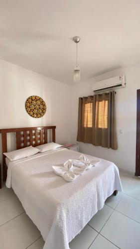 a bedroom with a bed with a white bedspread at Praia Jeri House in Jericoacoara
