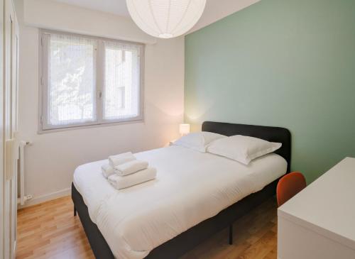 a bedroom with a bed with towels on it at Nid des Loriots - 3 Ch - Parking - Belle Beille Université in Angers