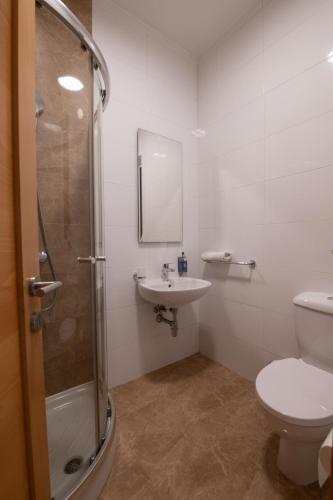 a bathroom with a shower and a toilet and a sink at Bayview Seafront 5A in St. Julianʼs