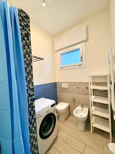 a bathroom with a washing machine and a toilet at The Sea Pearl Suite in Punta Marina