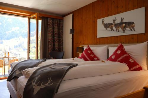 a bedroom with a bed with deer on the wall at Hotel Cabana in Grindelwald