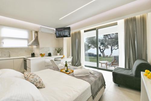 a bedroom with two beds and a kitchen with a window at Blue Residences in Paralia Vrachou