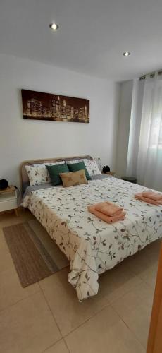 a bedroom with a large bed with white sheets and green pillows at Pont de Ferro Sunny Flat - Mediterránea Sunny Keys in Benicàssim
