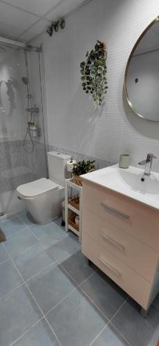 a bathroom with a sink and a toilet and a mirror at Pont de Ferro Sunny Flat - Mediterránea Sunny Keys in Benicàssim