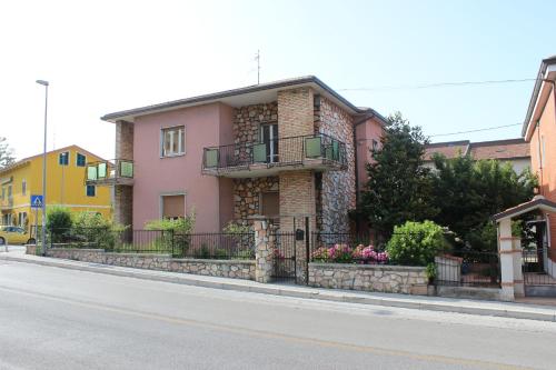 uma casa cor-de-rosa ao lado de uma rua em 4 PINI em Ancona