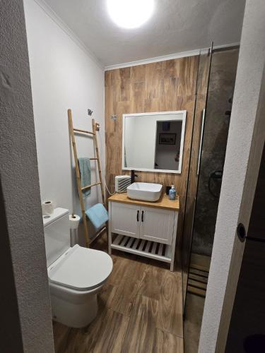 a bathroom with a toilet and a tv on the wall at Villa Rosa Boutique in Almancil