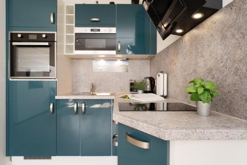 a kitchen with blue cabinets and a sink at Marina Wendtorf Oase in Wendtorf