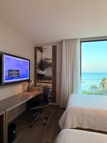 a hotel room with a desk with a computer and a window at InHouse Ciudad del Carmen in Ciudad del Carmen
