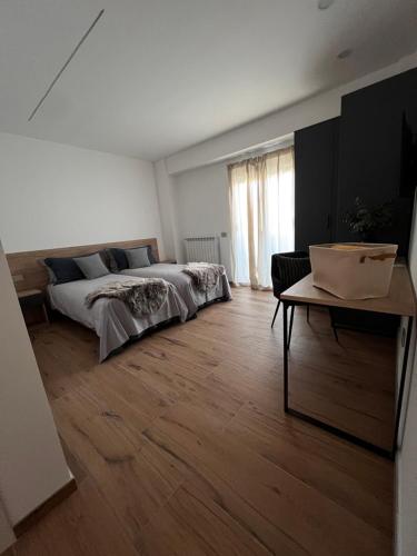 a white bedroom with a bed and a table at Mood Valentina in Goriano Sicoli