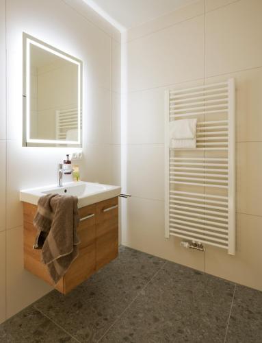 ein weißes Badezimmer mit Waschbecken und Spiegel in der Unterkunft Unser Hotel in Eggenfelden