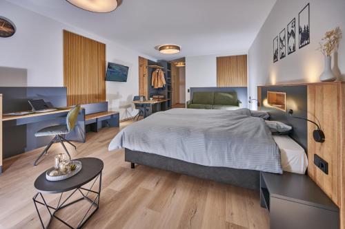 ein Schlafzimmer mit einem großen Bett und einem Schreibtisch in der Unterkunft Unser Hotel in Eggenfelden