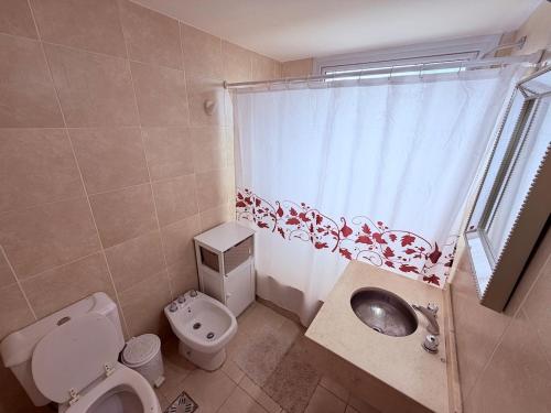 a bathroom with a toilet and a sink and a window at Puerto Amarras Apartment in Santa Fe