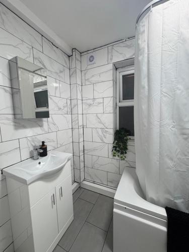 a white bathroom with a sink and a toilet at Comfort at Sunderlands in Forest Hill